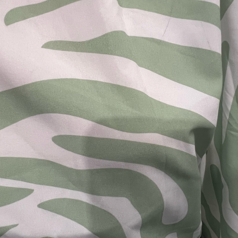 single-sleeved blouse with white background and green print